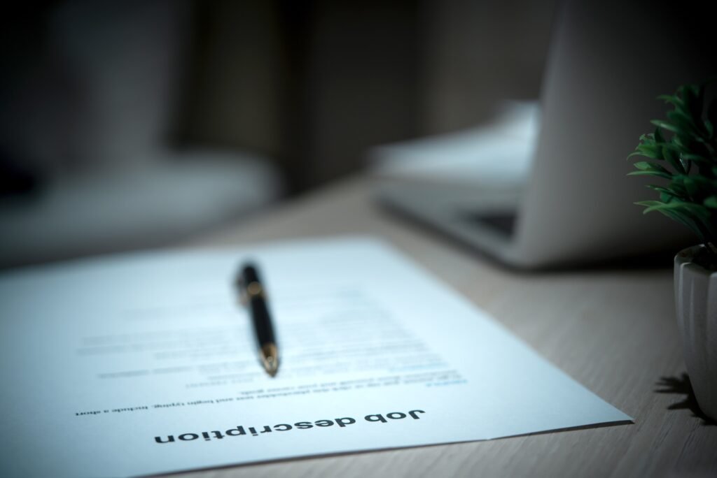 Job Description document with Pen on the table.